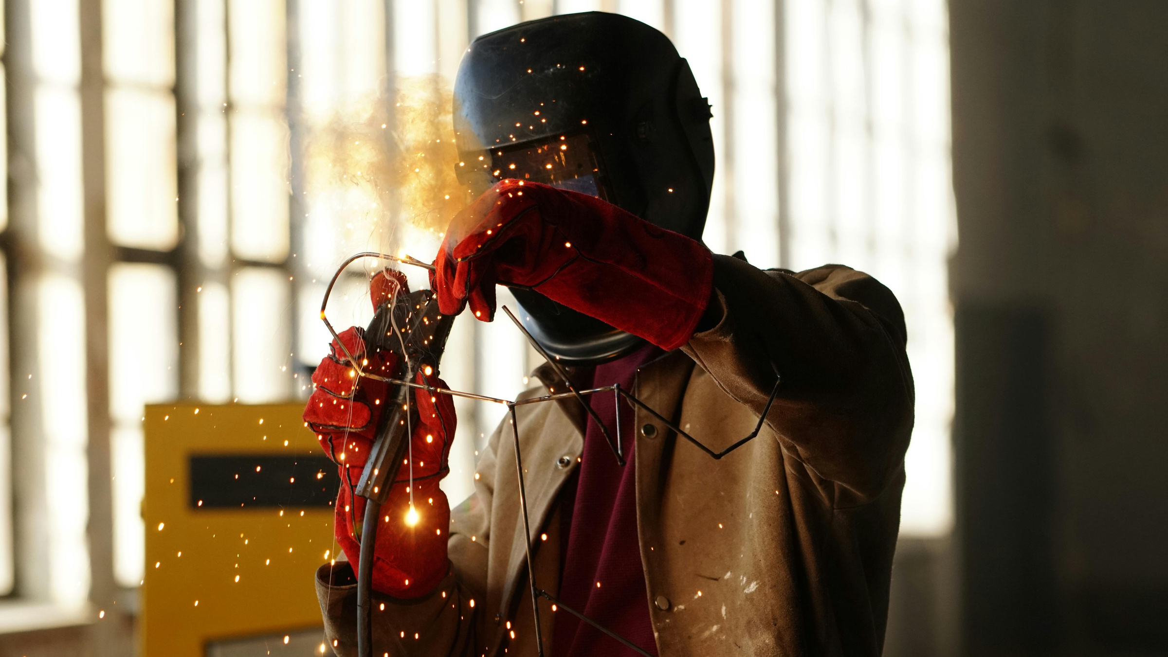 Technician performing welding work with sparks